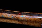 The Ladybug inlays are Bloodwood & black stone is inlaid onto that.